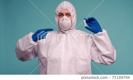 A male doctor in protective overalls and a mask A male doctor in protective overalls and a mask 75189794