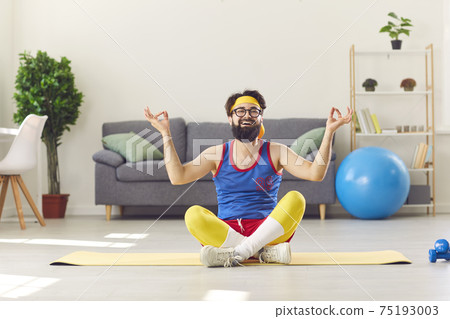 Funny happy man in retro sportswear sitting in easy yoga pose and learning to meditate Funny happy man in retro sportswear sitting in easy yoga pose and learning to meditate 75193003