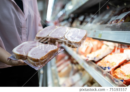 Asian woman chooses smoked ham in a vacuum package,selecting food quality,hygienic,female purchasing sausages pack in refrigerator shelves,shopping food in supermarket,buying, hoarding necessary food Asian woman chooses smoked ham in a vacuum package,selecting food quality,hygienic,female purchasing sausages pack in refrigerator shelves,shopping food in supermarket,buying, hoarding necessary food 75193557