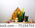 Easter eggs in a paper bag among the daffodils. 75194769
