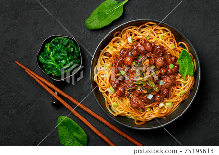 Bakmi or Mie Ayam in black bowl on dark slate table top. Indonesian cuisine noodles meat dish. Bakmi or Mie Ayam in black bowl on dark slate table top. Indonesian cuisine noodles meat dish. 75195613