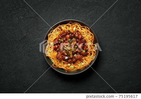 Bakmi or Mie Ayam in black bowl on dark slate table top. Indonesian cuisine noodles meat dish. Bakmi or Mie Ayam in black bowl on dark slate table top. Indonesian cuisine noodles meat dish. 75195617