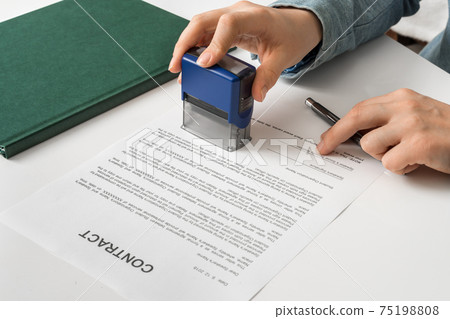 Business woman putting stamp on documents in the office 75198808