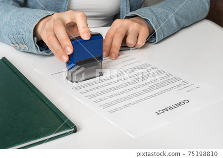 Business woman putting stamp on documents in the office 75198810