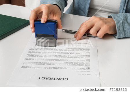 Business woman putting stamp on documents in the office 75198813