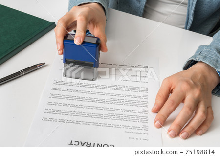 Business woman putting stamp on documents in the office 75198814