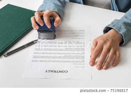 Business woman putting stamp on documents in the office 75198817