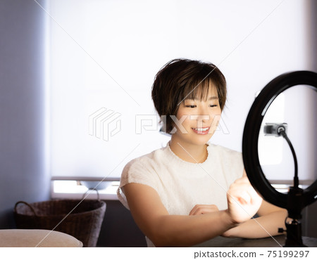 A woman who broadcasts live on her smartphone A woman who broadcasts live on her smartphone 75199297