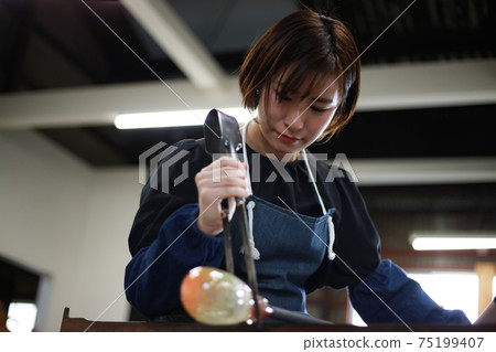 女人做一個玻璃容器吹製的玻璃 75199407