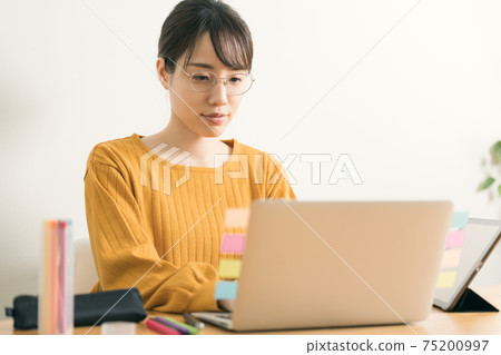 Young woman typing on a computer 75200997