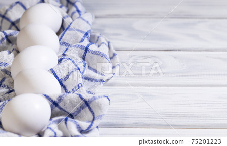 Lots of Fresh Raw Chicken Eggs in a Cardboard box, Chicken white eko eggs on a piece of cloth, Flatlay, Copyspace 75201223