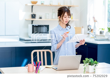 Young business woman teleworking at home Young business woman teleworking at home 75202029