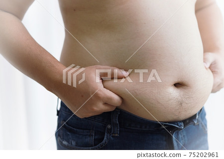 Man with fat belly in dieting concept. Overweight man touching his fat belly and want to lose weight. 75202961