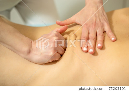 Young woman relaxing with hand massage at beauty spa. Young woman relaxing with hand massage at beauty spa. 75203101