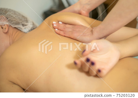 Young woman relaxing with hand massage at beauty spa. 75203120