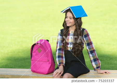 Fun filled learning. Funny child hold book on head. School 75203337