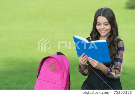 Little kid in uniform with school bag read library book natural landscape, reading, copy space Little kid in uniform with school bag read library book natural landscape, reading, copy space 75203338