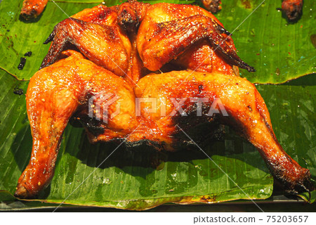 Thai grilled chicken on banana leaf is a delicious food in Asian Thailand Thai grilled chicken on banana leaf is a delicious food in Asian Thailand 75203657