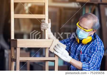 Carpenter, Senior man sanding wooden fence in workplace using work tool. Carpenter, Senior man sanding wooden fence in workplace using work tool. 75205656