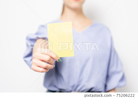 Young woman showing a yellow card Young woman showing a yellow card 75206222