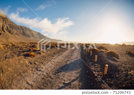Scenic landscape with dirty road and mountains in Lanzarote, Canary islands 75206743