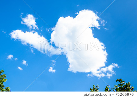white fluffy cloud in blue sky over green trees white fluffy cloud in blue sky over green trees 75206976