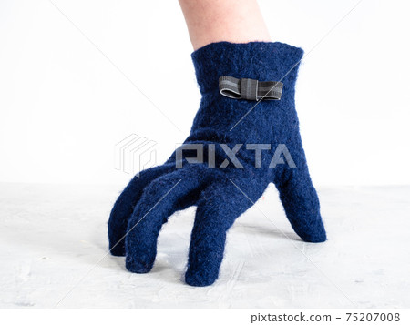 hand in glove with bow tie leans on gray board hand in glove with bow tie leans on gray board 75207008