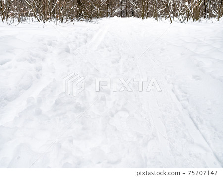 footprints and ski tracks at snowy surface footprints and ski tracks at snowy surface 75207142