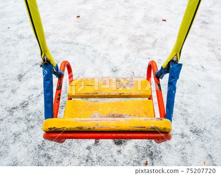 iced yellow seat of swing on children playground iced yellow seat of swing on children playground 75207720