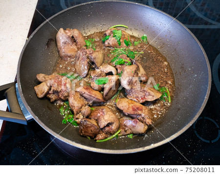 chicken liver with herbs are frying in pan 75208011