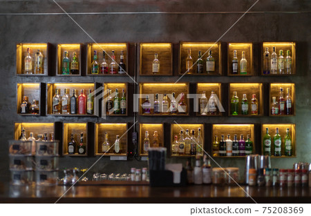 Wide variety of bottles of alcohol or liqueur are placed on the shelves of a vintage bar in Chiangmai, THAILAND: March 4, 2021 Wide variety of bottles of alcohol or liqueur are placed on the shelves of a vintage bar in Chiangmai, THAILAND: March 4, 2021 75208369