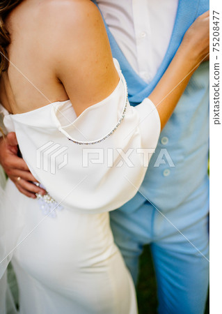 close-up details. bride and groom gently cuddle in park. touches. 75208477