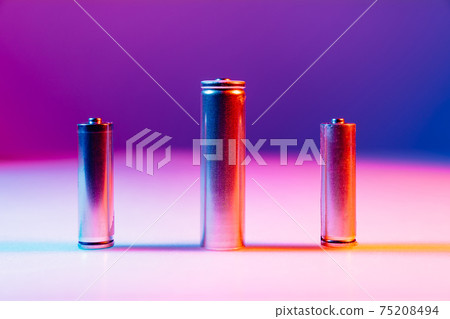 AA and 8650 Li-ion silver batteries on illuminated by multicolored light AA and 8650 Li-ion silver batteries on illuminated by multicolored light 75208494