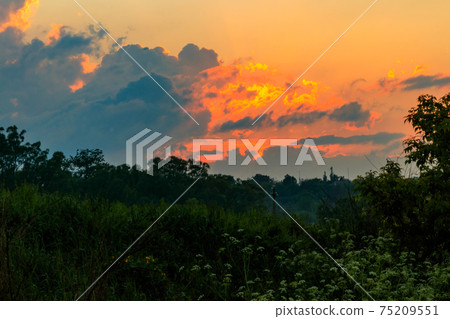 Orange sunset over meadow at spring Orange sunset over meadow at spring 75209551