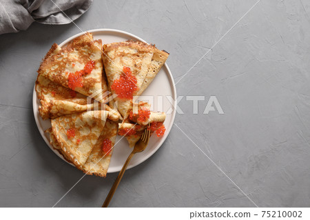 Russian thin pancakes or blini with red caviar on grey. Russian thin pancakes or blini with red caviar on grey. 75210002