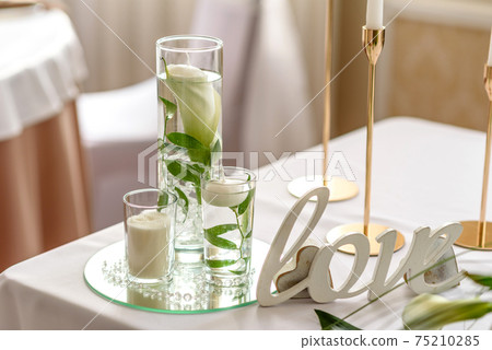 Beautiful decoration of the wedding holiday with flowers and greenery with florist decoration 75210285