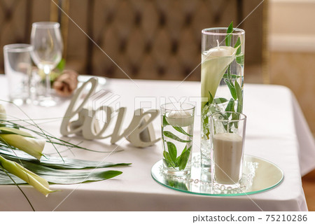 Beautiful decoration of the wedding holiday with flowers and greenery with florist decoration 75210286