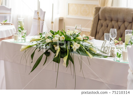 Beautiful decoration of the wedding holiday with flowers and greenery with florist decoration 75210314