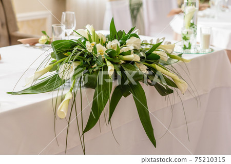 Beautiful decoration of the wedding holiday with flowers and greenery with florist decoration 75210315