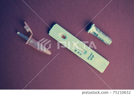 test for coronavirus on a purple background. on a matte background a sensitive strip for coronavirus, a pink lancet and a container for a physical solution test for coronavirus on a purple background. on a matte background a sensitive strip for coronavirus, a pink lancet and a container for a physical solution 75210632