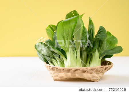 Fresh Bok Choy or Pak Choi (Chinese cabbage) in a basket on white and yellow background Fresh Bok Choy or Pak Choi (Chinese cabbage) in a basket on white and yellow background 75216926