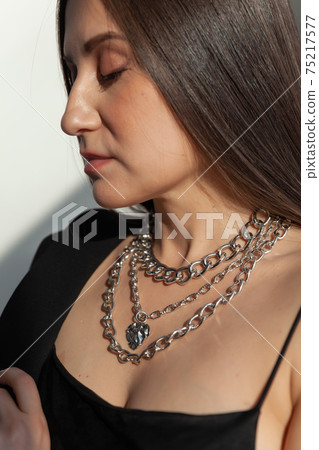 Beautiful model brunette in modern silver metal necklace, many chains Beautiful model brunette in modern silver metal necklace, many chains 75217577