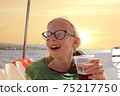 Young blonde girl in glasses have fun discovering islands on summer coastal cruise. Travel adventure, yachting with kids on family vacation. 75217750