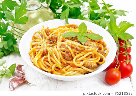 Spaghetti with bolognese in plate on light wooden board Spaghetti with bolognese in plate on light wooden board 75218552