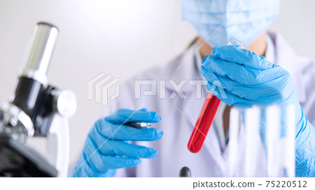 scientists researching in laboratory in white lab coat, gloves analysing, looking at test tubes sample, biotechnology concept 75220512