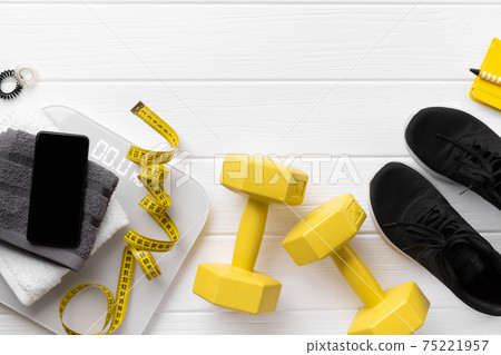 Flat lay top view sport equipments, sneakers and smartphone on wooden background Flat lay top view sport equipments, sneakers and smartphone on wooden background 75221957