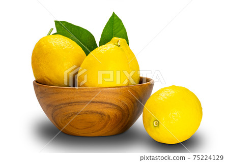 Ripe lemons with leaves in a wooden bowl on white background. Ripe lemons with leaves in a wooden bowl on white background. 75224129