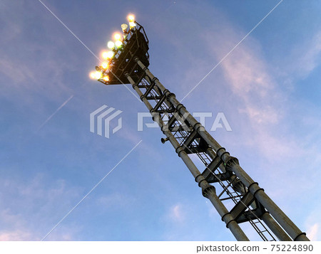傍晚時分，站在粉紅色和藍色的天空中的照明的塔 75224890
