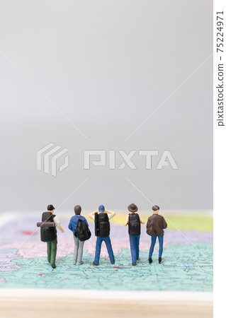Miniature people Backpacker walking on map Miniature people Backpacker walking on map 75224971