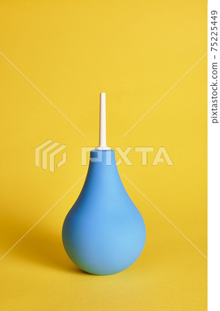 Medical rubber enema on yellow background with copy space. Shot with light shadow. Medical rubber enema on yellow background with copy space. Shot with light shadow. 75225449